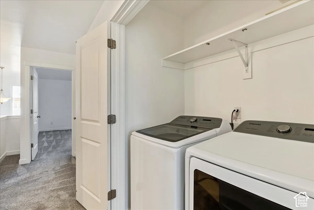 Dedicated laundry area featuring a white built-in shelf and modern appliances