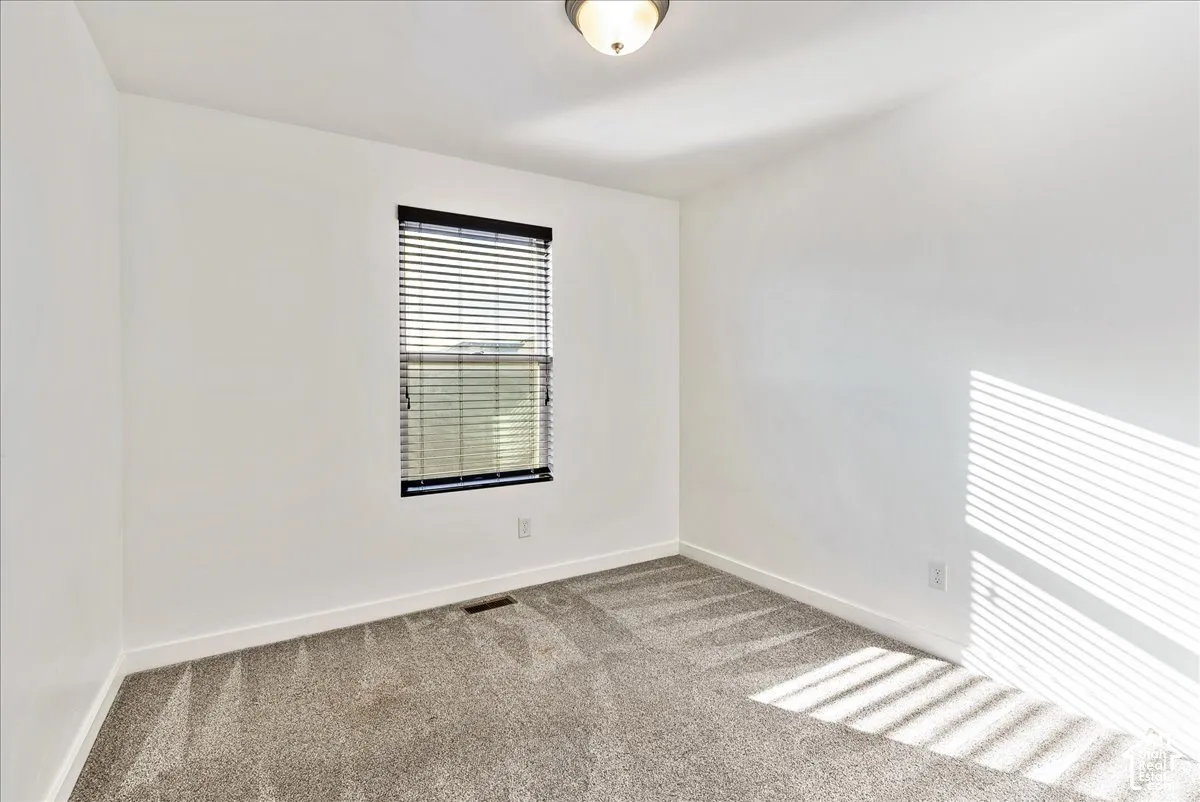 Neutral wall finishes with a window featuring horizontal blinds