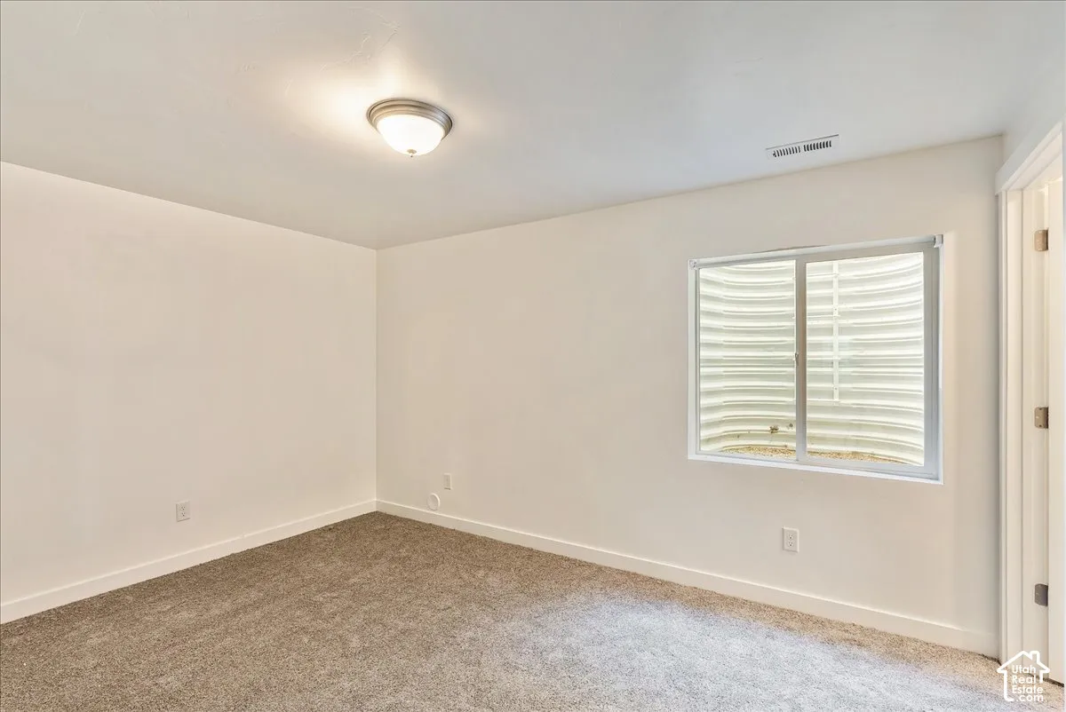 Recessed window with white trim, wall-to-wall carpeting, white painted walls, and an overhead flush mount light fixture