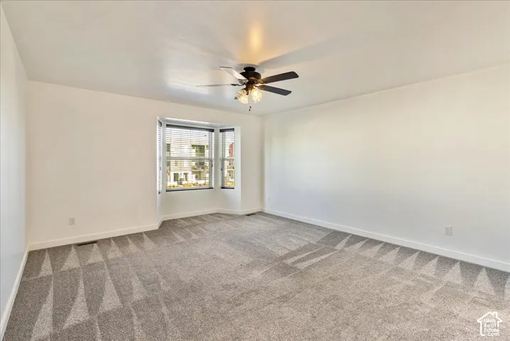 Recessed bay window with horizontal blinds, overhead ceiling fan with light kit, and neutral wall paint