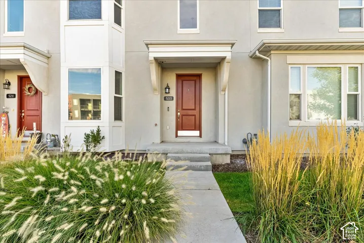 Stucco exterior with a wood-panel front door and a covered entryway