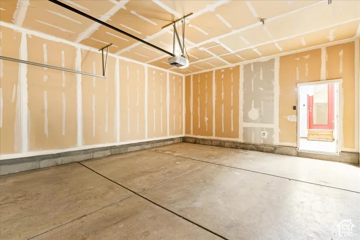 Spacious garage with concrete flooring, drywall-ready walls, and an automatic garage door opener