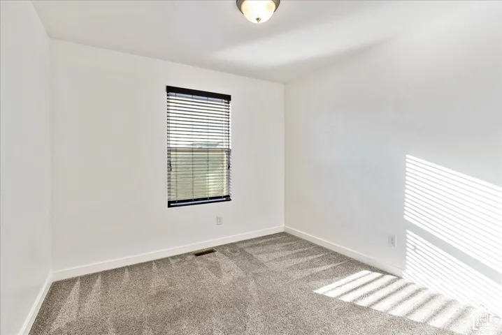 Neutral wall finishes with a window featuring horizontal blinds