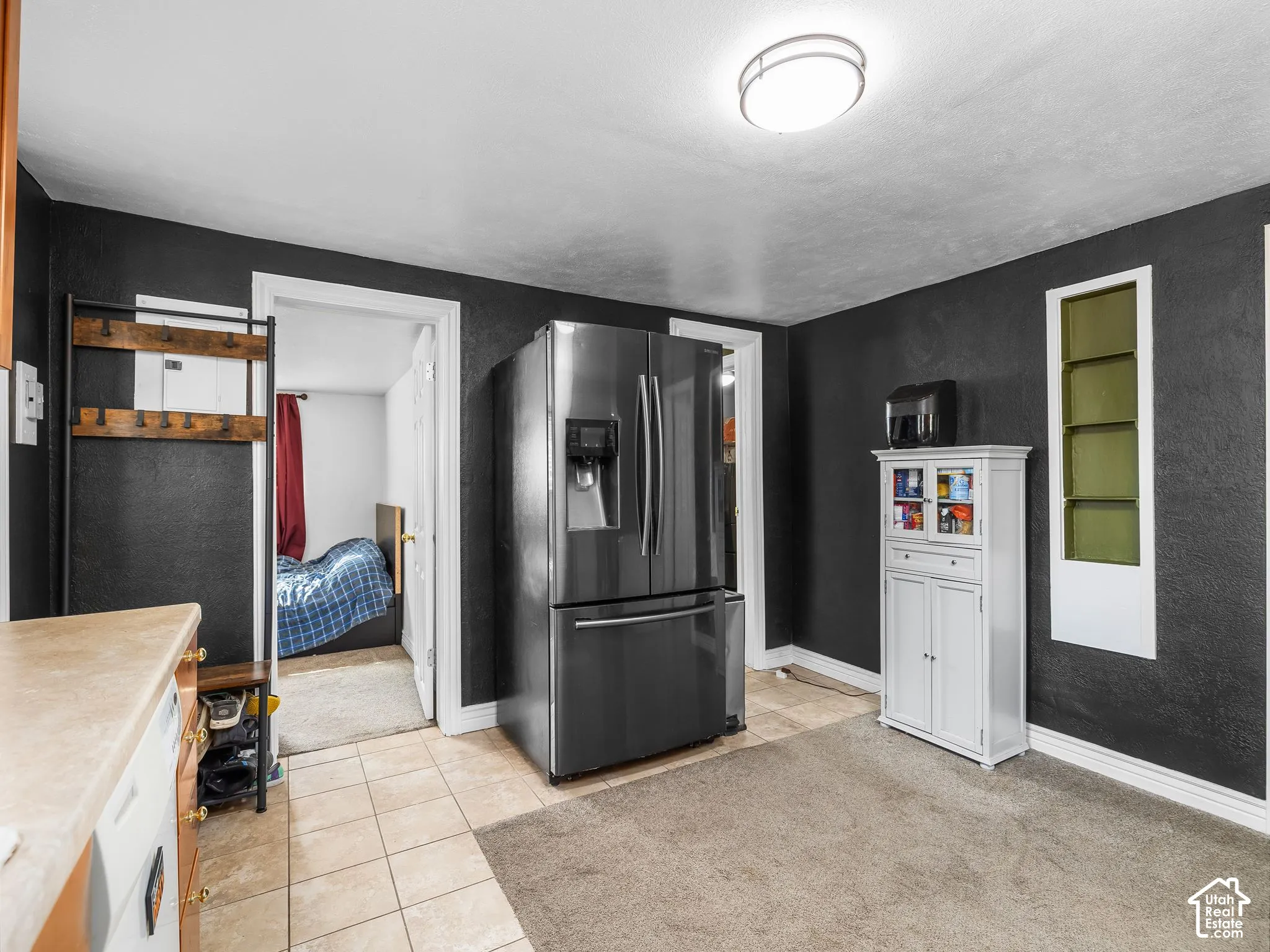 Stainless steel refrigerator, tile flooring, and overhead flush-mount lighting