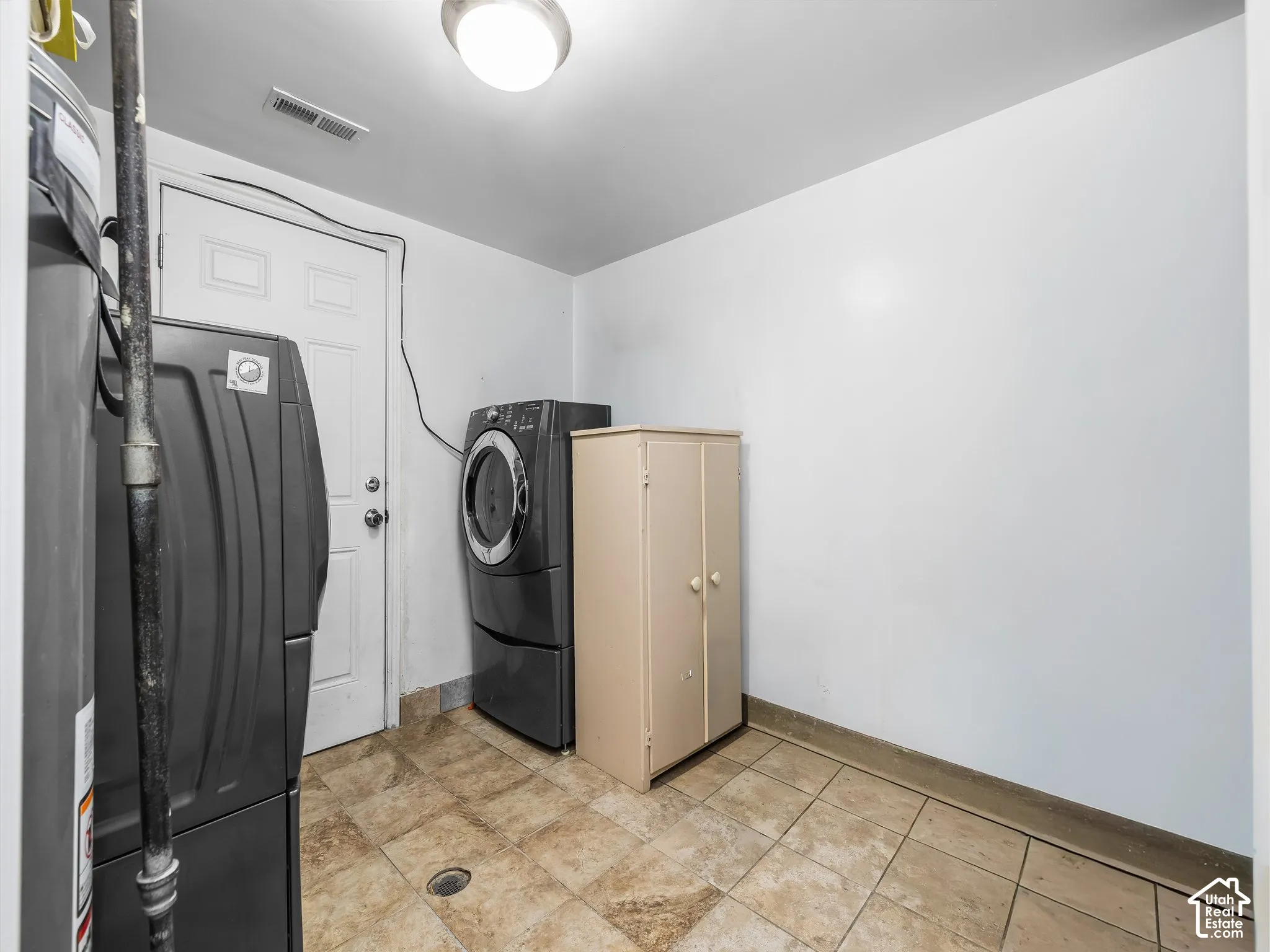 Utility room featuring tiled flooring and a flush-mounted ceiling light