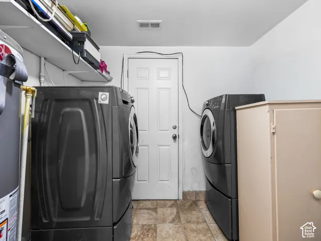 Utility area with built-in shelving, tiled flooring, and a white paneled door