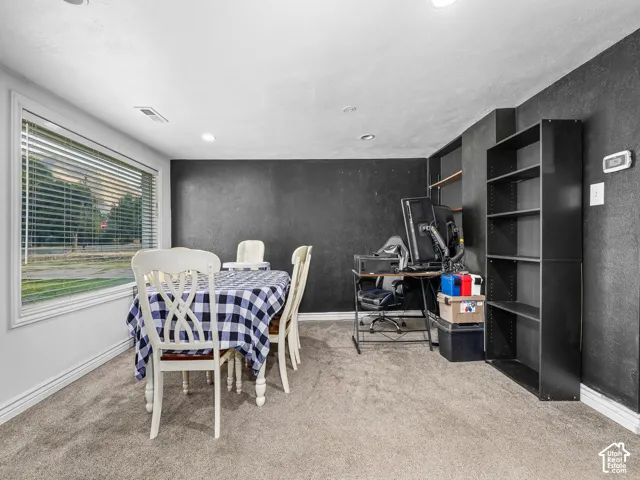 Carpeted room featuring a large window, recessed lighting, and built-in shelving