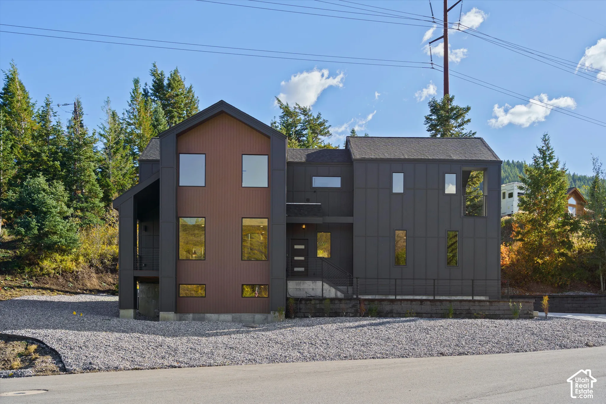Front. Contemporary exterior featuring dark vertical siding and brown wood-panel siding