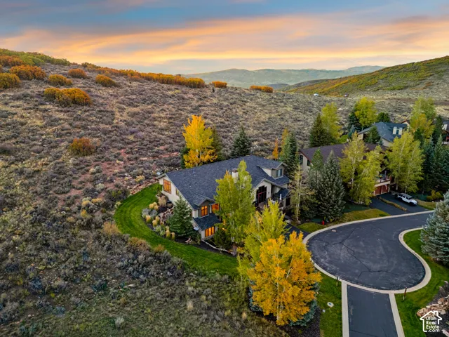 Multi-level home with a dark shingled roof, light-colored siding, and stone accents