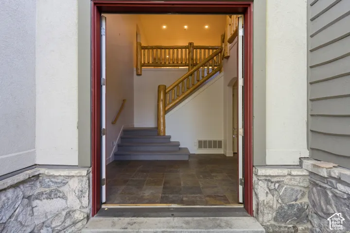 Stone exterior accents, tile flooring, wood-finish staircase and railing, recessed lighting