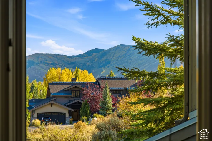 Modern home exterior with a dark roof and mountain backdrop