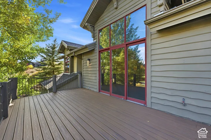 Spacious outdoor deck with composite decking, black metal railing, and large glass sliding doors