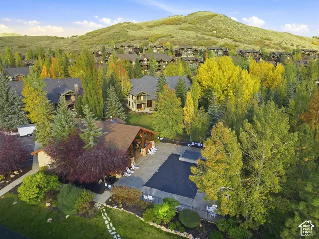 Mountainous terrain with extensive landscaping, a covered outdoor pavilion, and an outdoor pool area with a covered spa