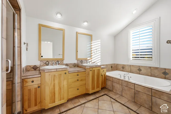 Dual vanity with light wood cabinetry, white sinks, and chrome fixtures