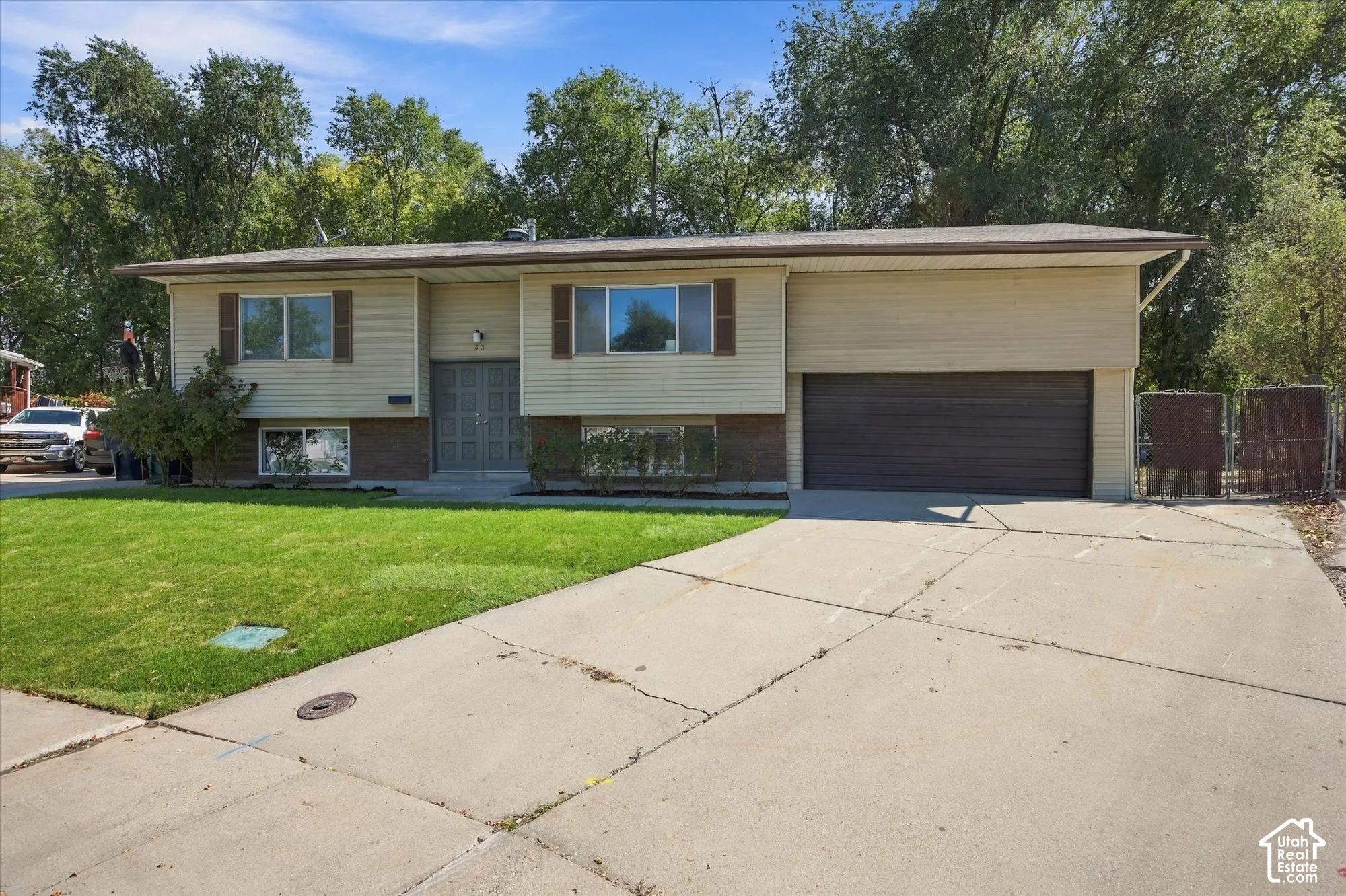 Split-level residence featuring a two-car garage, concrete driveway, and a front lawn