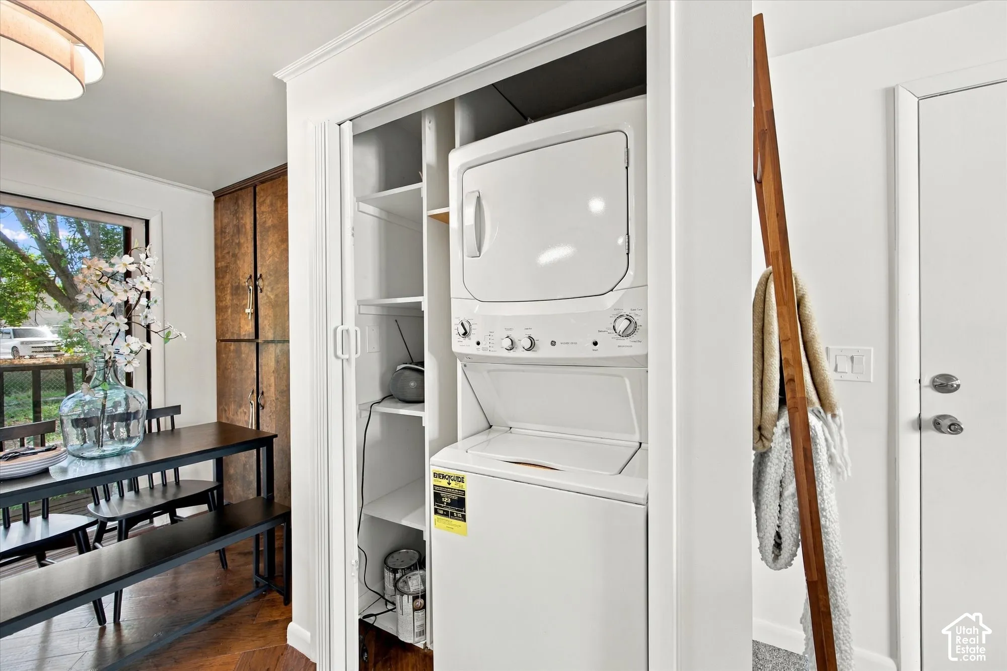 Built-in laundry closet with stacked washer and dryer unit, and integrated shelving