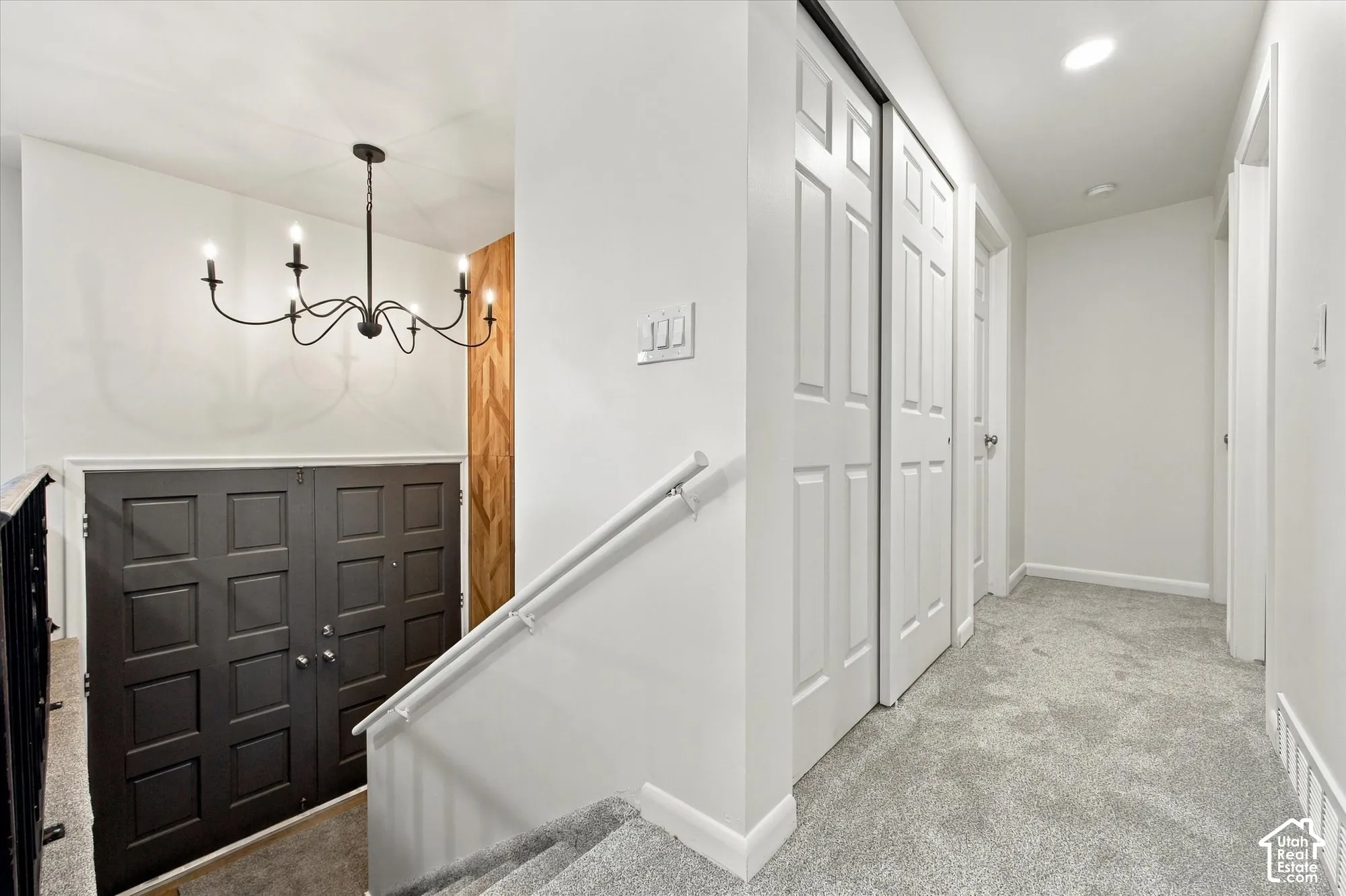 Gray carpeted staircase with white handrails