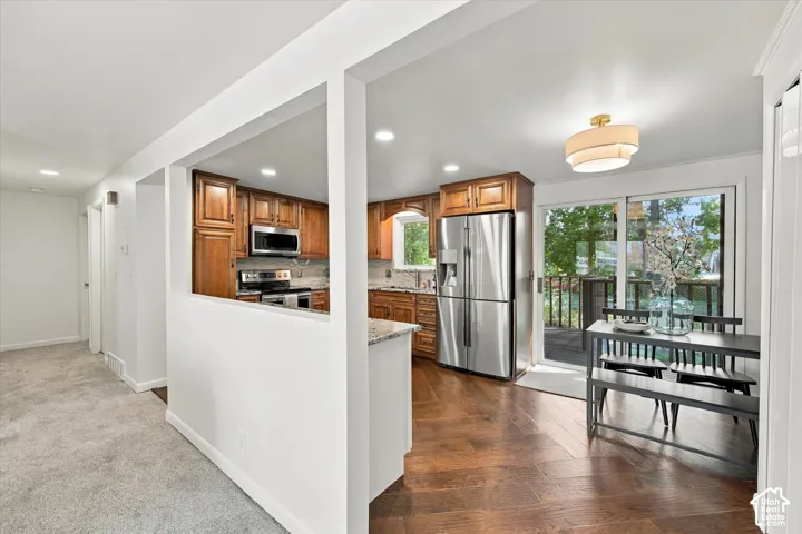 Kitchen featuring wood cabinetry, stainless steel appliances, and stone countertops