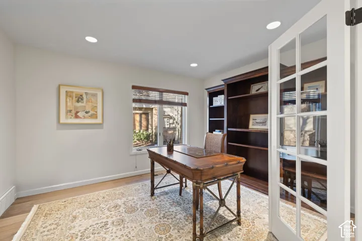 Recessed lighting, wood-finish flooring, and a window with blinds