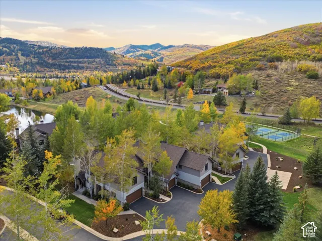 Mountain landscape with multiple residences, a reflecting pond, and a tennis court