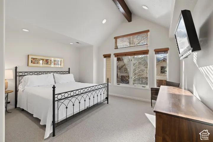 Vaulted ceiling with exposed wood beams, recessed lighting, and large windows with integrated blinds