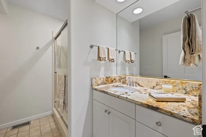 Vanity with a granite countertop, undermount sink, and chrome faucet