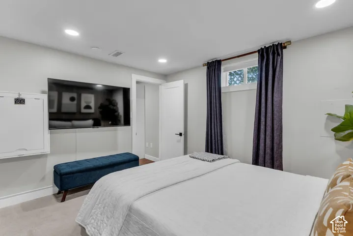 Recessed ceiling lighting, light gray wall paint, wood-finish flooring, white trim, and a high window