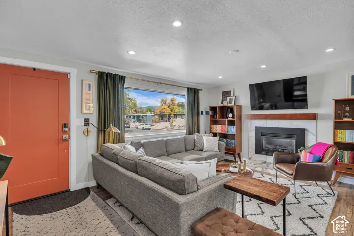 Recessed lighting, wood-finish flooring, and a fireplace with a wood mantle