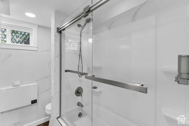Shower-over-tub combination with a sliding glass enclosure and chrome fixtures