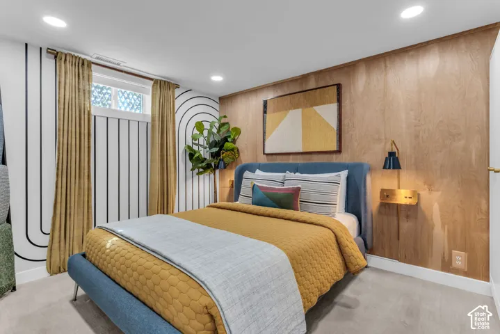 Recessed ceiling lighting, wood panel accent wall, wall-mounted light fixture, white trim, and carpeted flooring