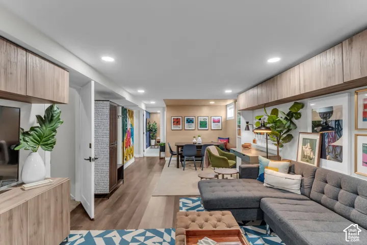 Recessed lighting, wood-finish flooring, built-in wall cabinetry, built-in shelving, and a built-in desk