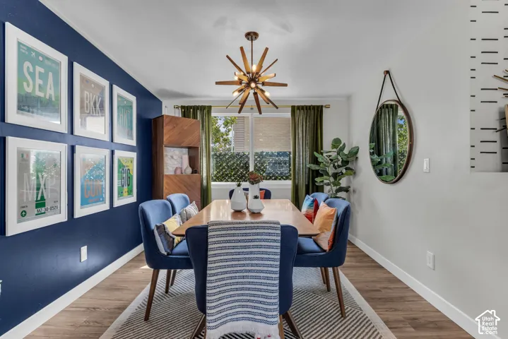 Wood-finish flooring, a contemporary sputnik chandelier, and a built-in wood-paneled cabinet