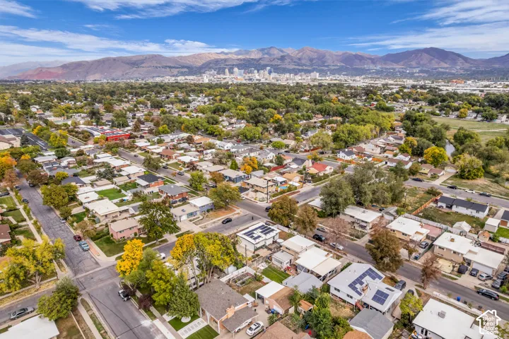 Residential neighborhood with mature trees, established street grid, and mountain backdrop