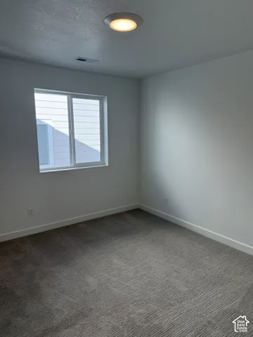 Recessed ceiling lighting, white walls, large window with white trim, gray patterned carpet