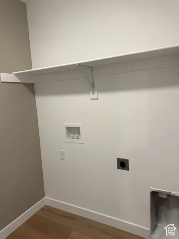 White wall-mounted shelving with support brackets, wood-finish flooring, and white baseboards