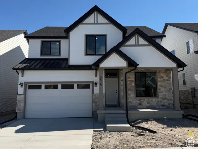 Contemporary exterior featuring white siding, stone accents, black trim, and a prominent gable roofline