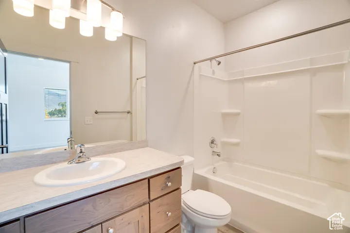 Vanity with an integrated sink, wood-finish cabinetry, and a full-width mirror