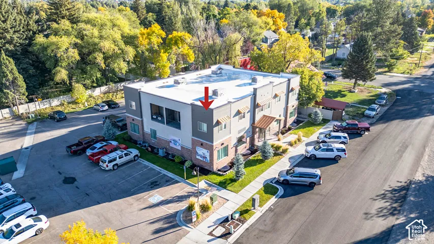 Modern commercial building with multi-story construction, brick accents, ample paved parking, and established landscaping