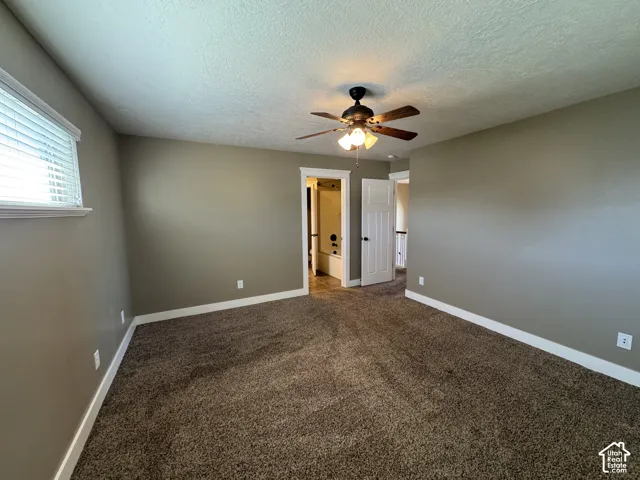 Wall-to-wall carpeting, window with horizontal blinds, ceiling fan with integrated lighting, white trim
