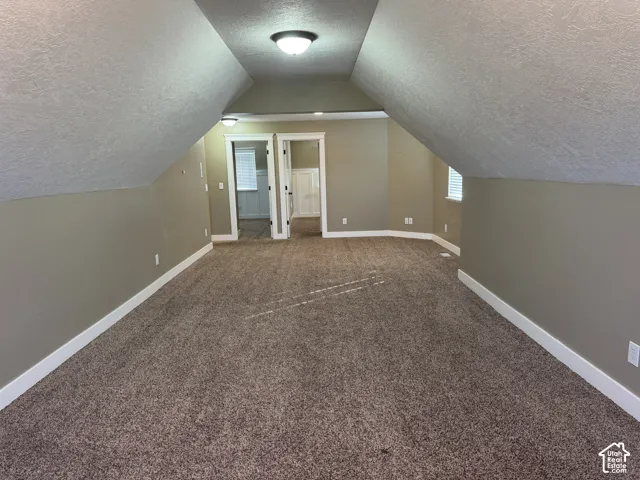 Spacious carpeted room with neutral wall tones, white trim, and recessed lighting