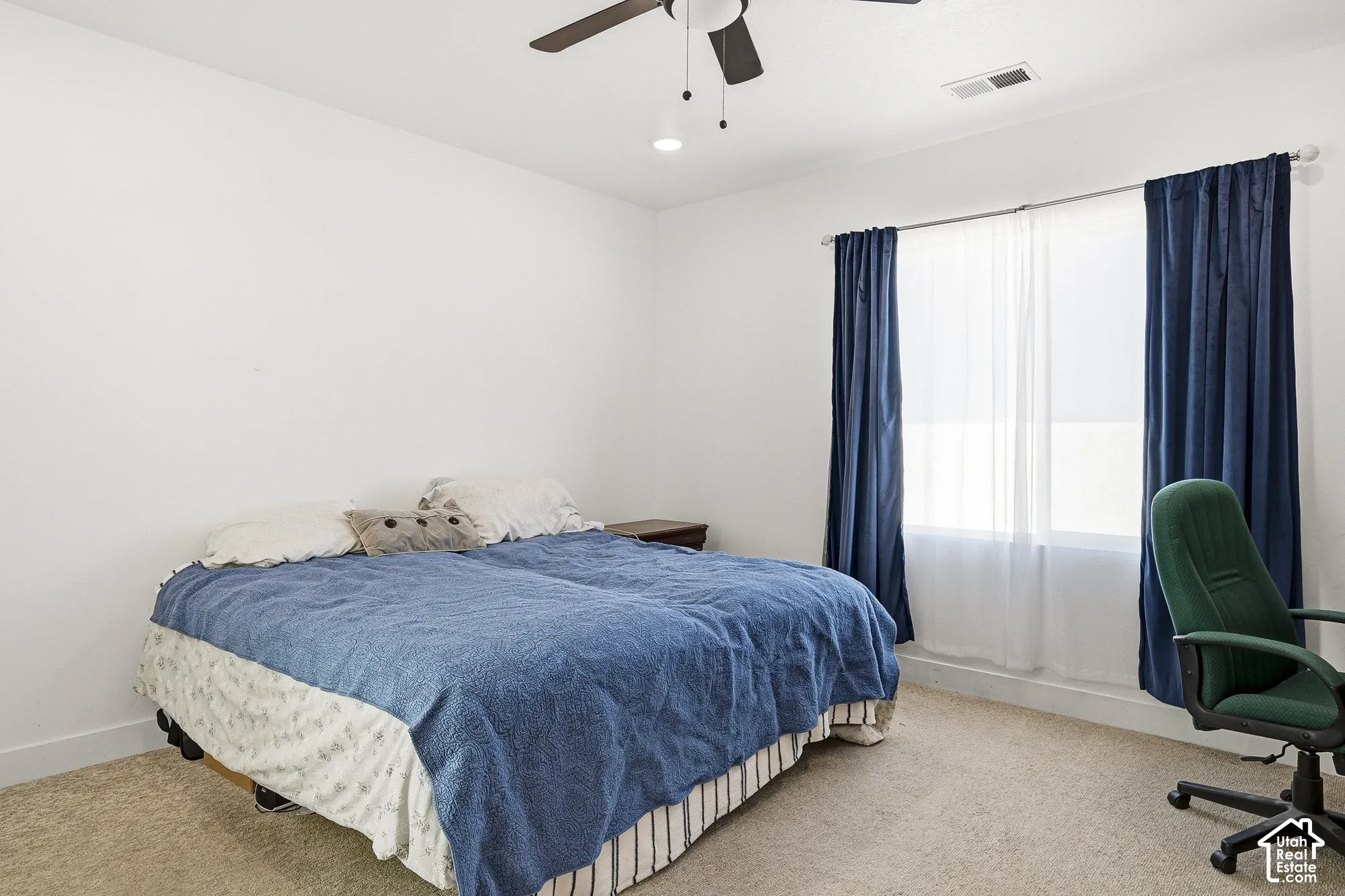 Bright room with a window featuring privacy blinds and full-length drapes