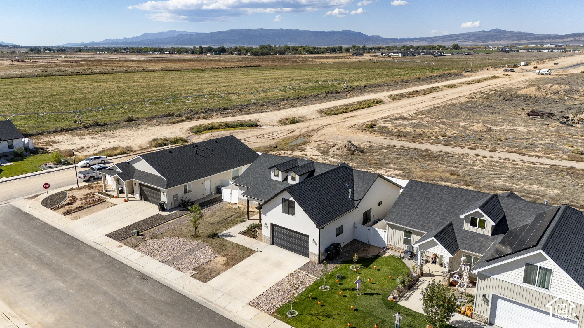 Newly constructed residential development featuring modern homes with dark asphalt shingle roofs and light-colored siding