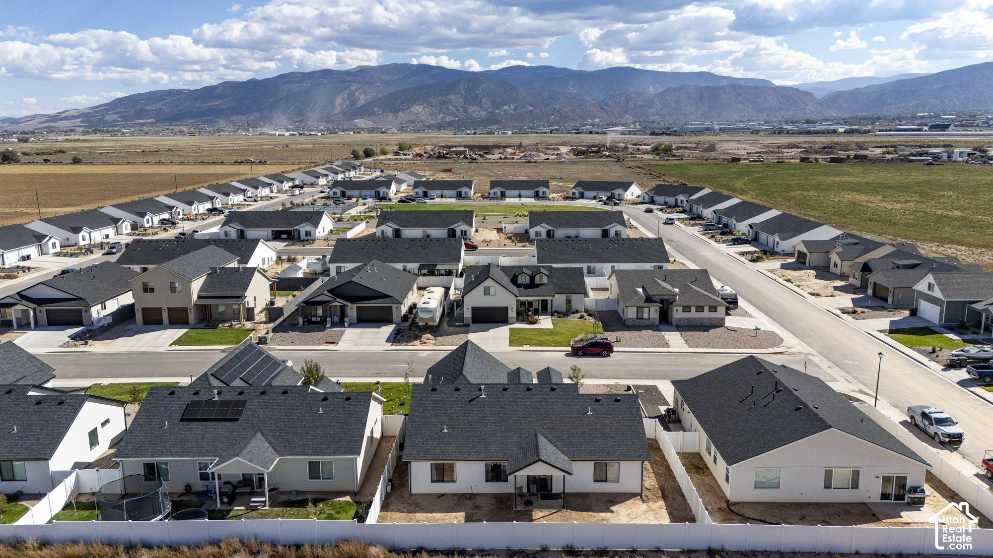 Newly developed residential community featuring modern single-story homes, asphalt shingle roofing, and mountain scenery