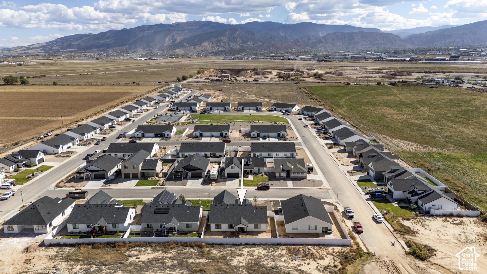 Newly developed residential community with single-story homes, paved streets, and mountain backdrop