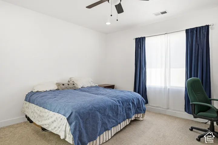 Bright room with a window featuring privacy blinds and full-length drapes