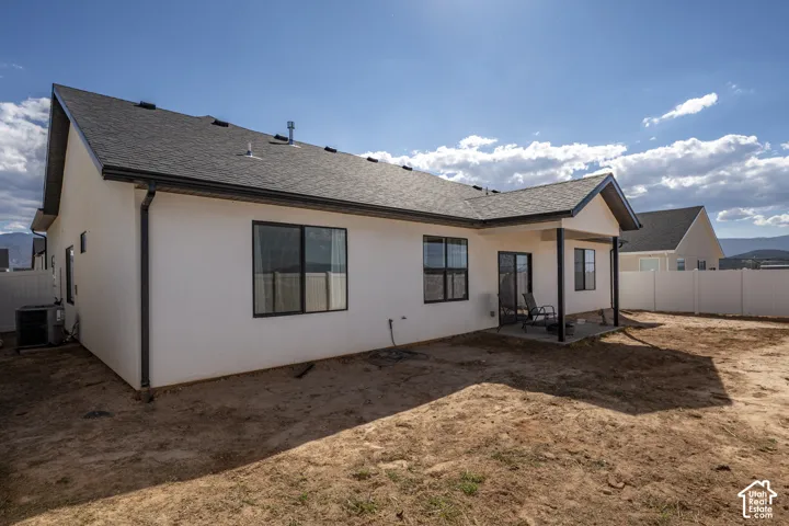 White stucco exterior with black-framed windows and a dark shingle roof