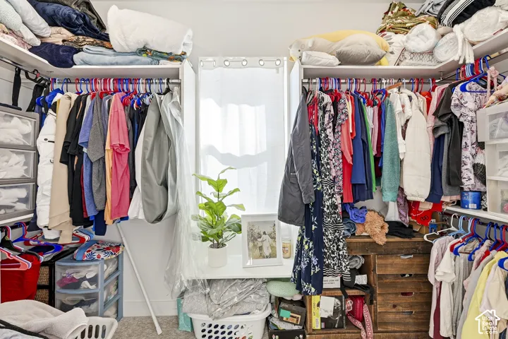 Walk-in closet featuring built-in shelving, clothing rods, and a window