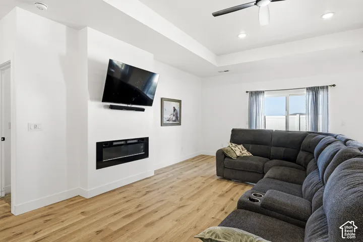 Recessed lighting, wood-finish flooring, electric fireplace, ceiling fan, and sliding glass door