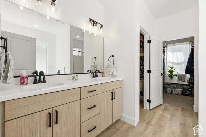 Double vanity with undermount sinks, wood-finish cabinetry, and matte black fixtures