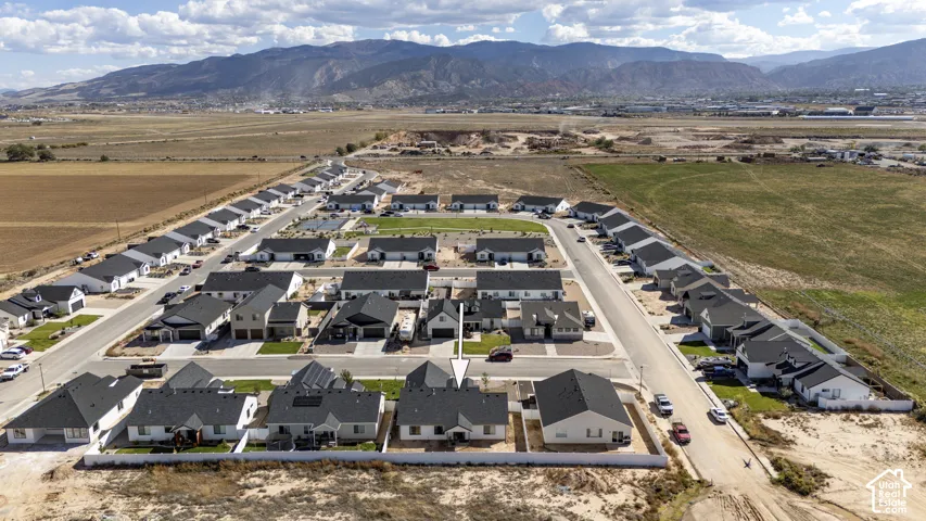 Newly developed residential community with single-story homes, paved streets, and mountain backdrop
